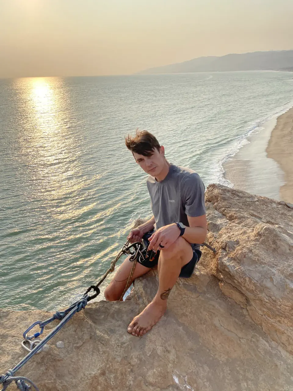 matt working at a cliff-top climbing anchor
